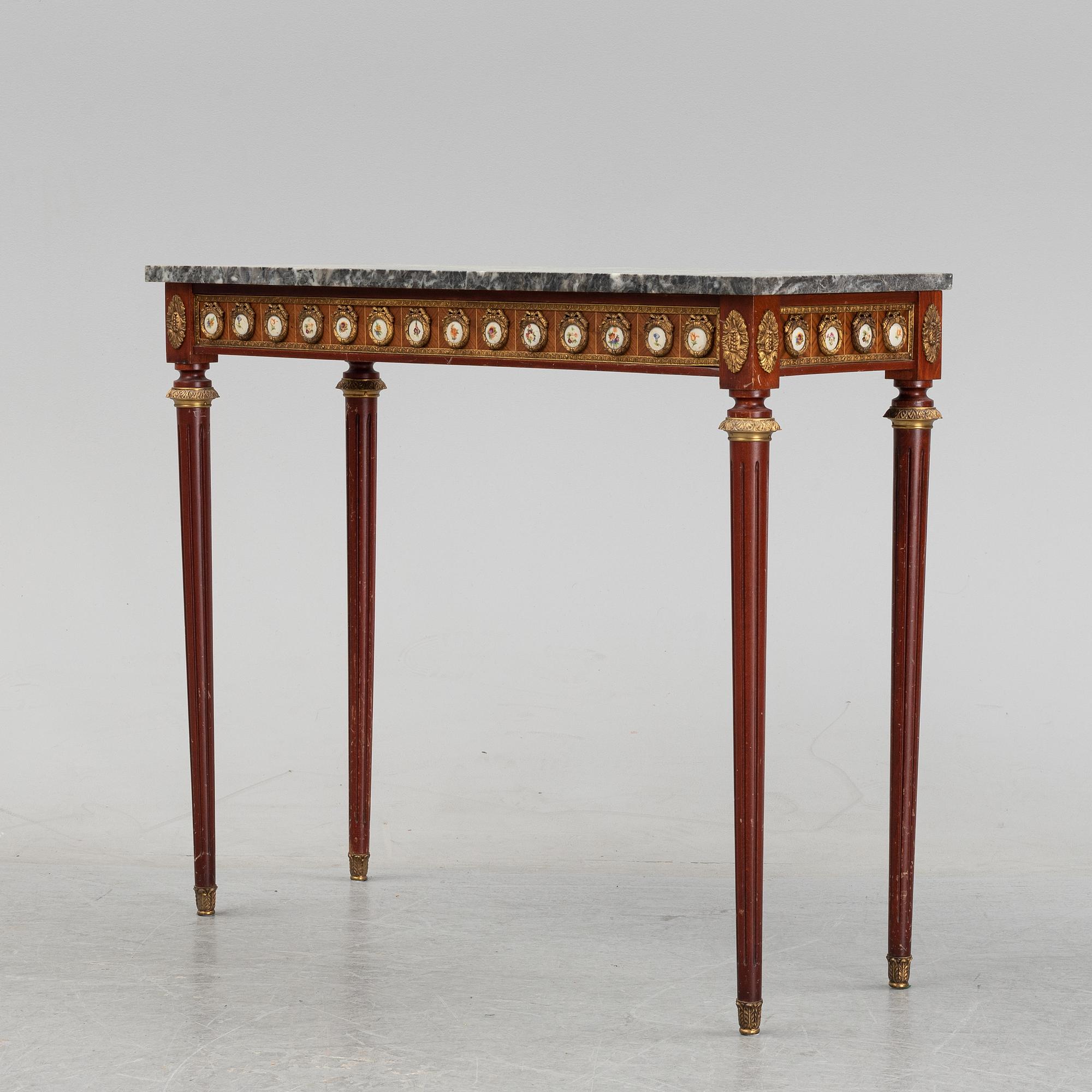 A Louis XVI style console table with a marble top.