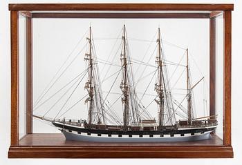 A model of a sailing ship with four masts in a glass and mahogany box by Gustav Sixten Wiman, 20th century.