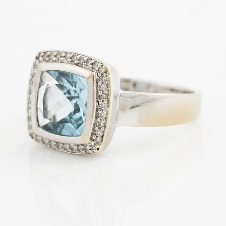 Ring 18K vitguld med en fasettslipad topas och runda briljantslipade diamanter.