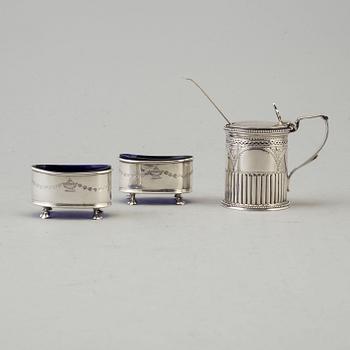 A silver mustard can and a pair of salt cellars. british. Dated 1879 resp. 1911.