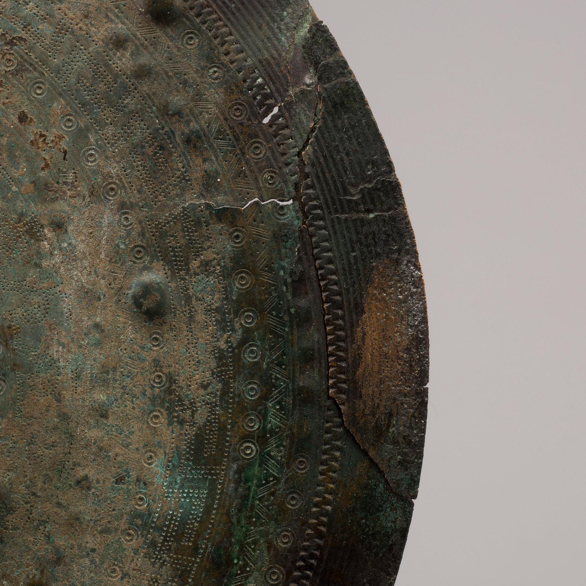 Three 20th century stone objects, with one bronze shield.