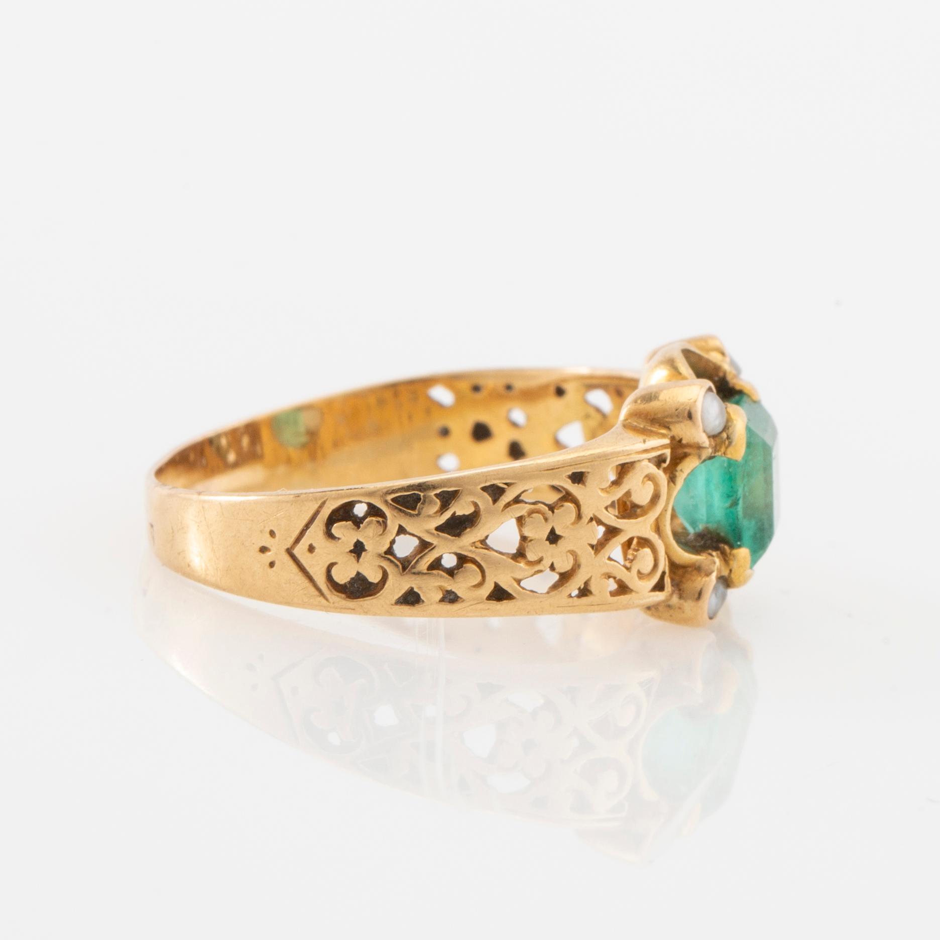 Ring in 18K gold with a step-cut emerald and seed pearls.
