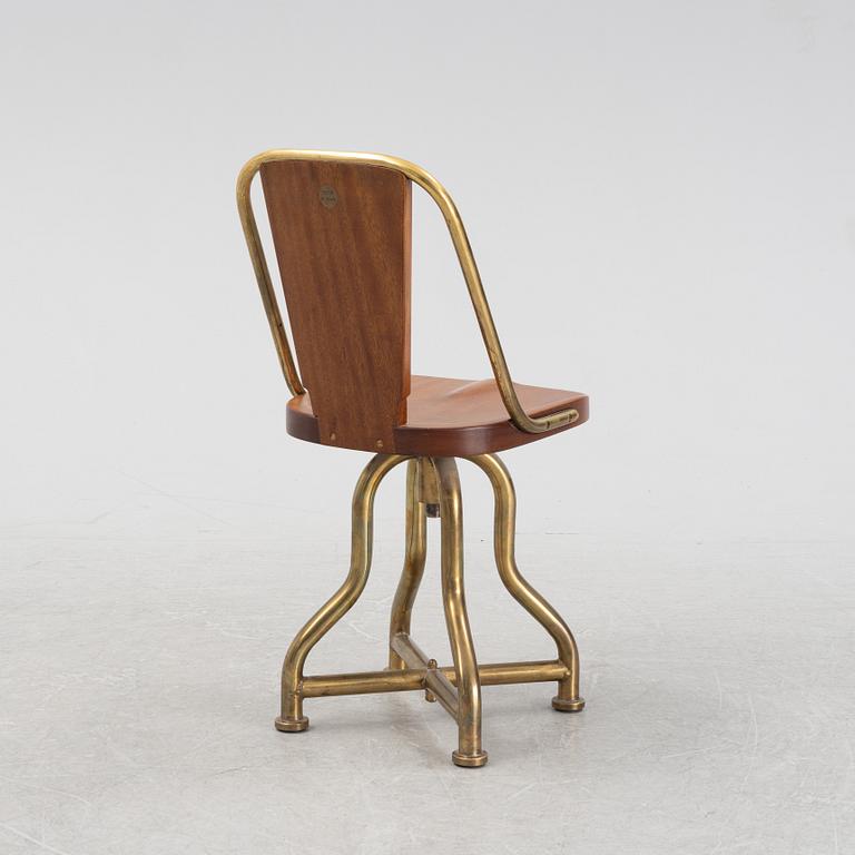 A brass and mahogany ships chair, from the ship Giuseppe Verdi, first half of the 20th Century.