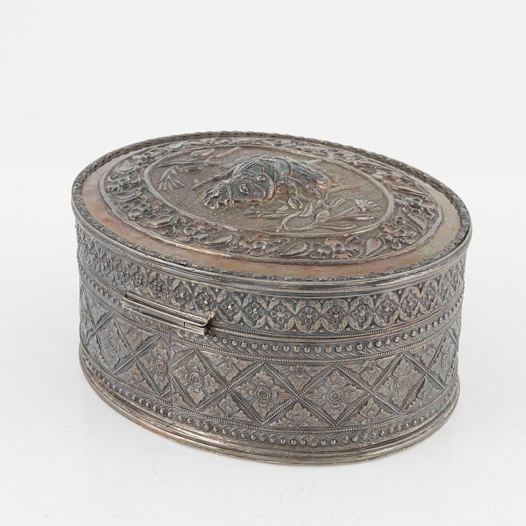 A South Asian box of low fineness silver, 20th century, and a Persian enamel box, second half of the 20th century.