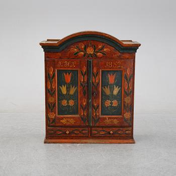 A Swedish provincial painted wall hanging cabinet, dated 1852.