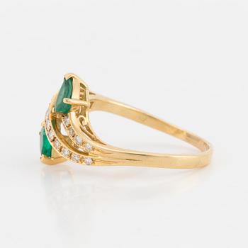 A ring set with pear-shaped emeralds and eight-cut diamonds.