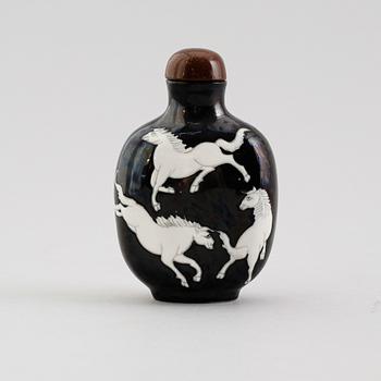 An enamelled porcelain snuff bottle with stopper, Qing dynasty (1644-1912).