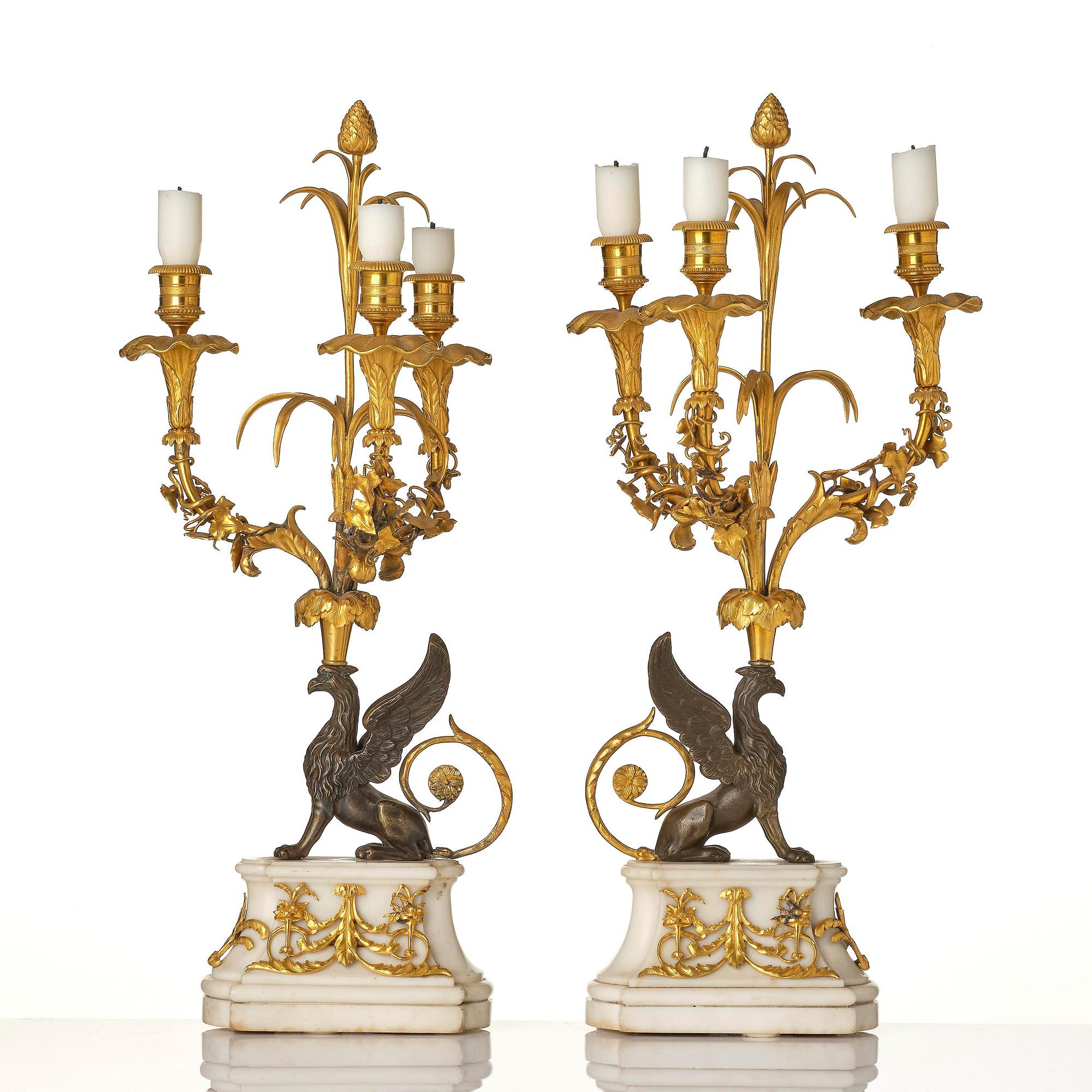 A pair of three-light Louis XVI patinated and ormolu candelabra in the manner of François Rémond, late 18th century.
