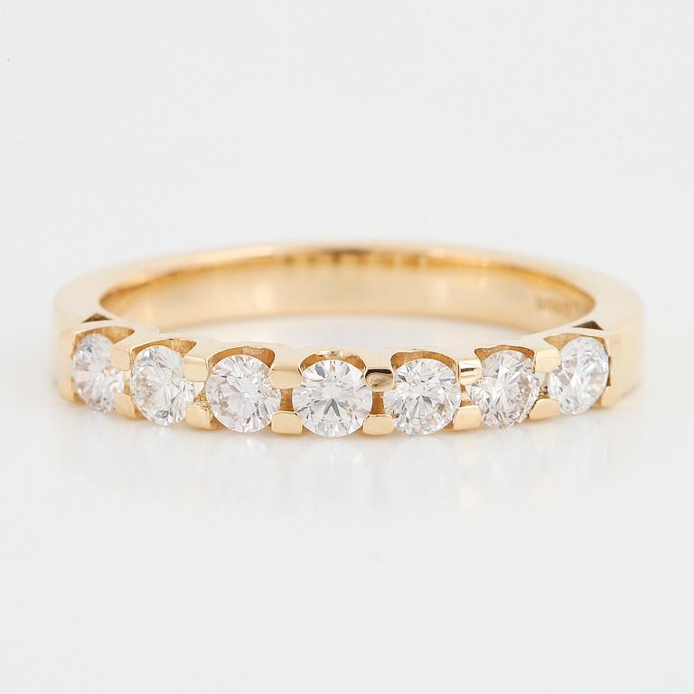 An 18K gold ring set with round brilliant cut diamonds.