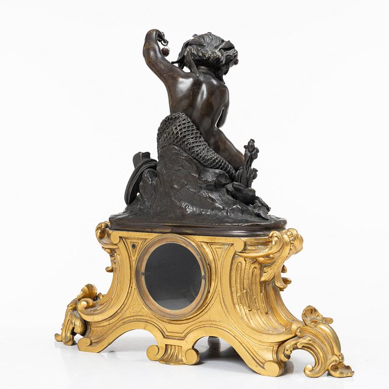 A Rococo style mantle clock and pair of candelabra, France, late 19th Century.