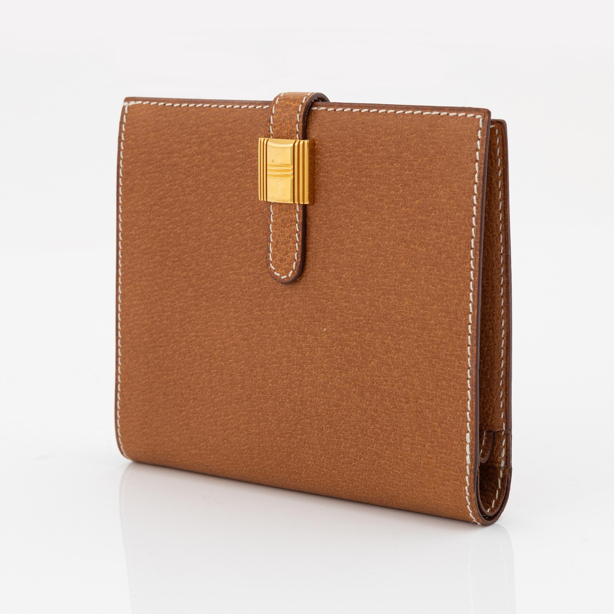 Hermès, a brown leather gold lock wallet.
