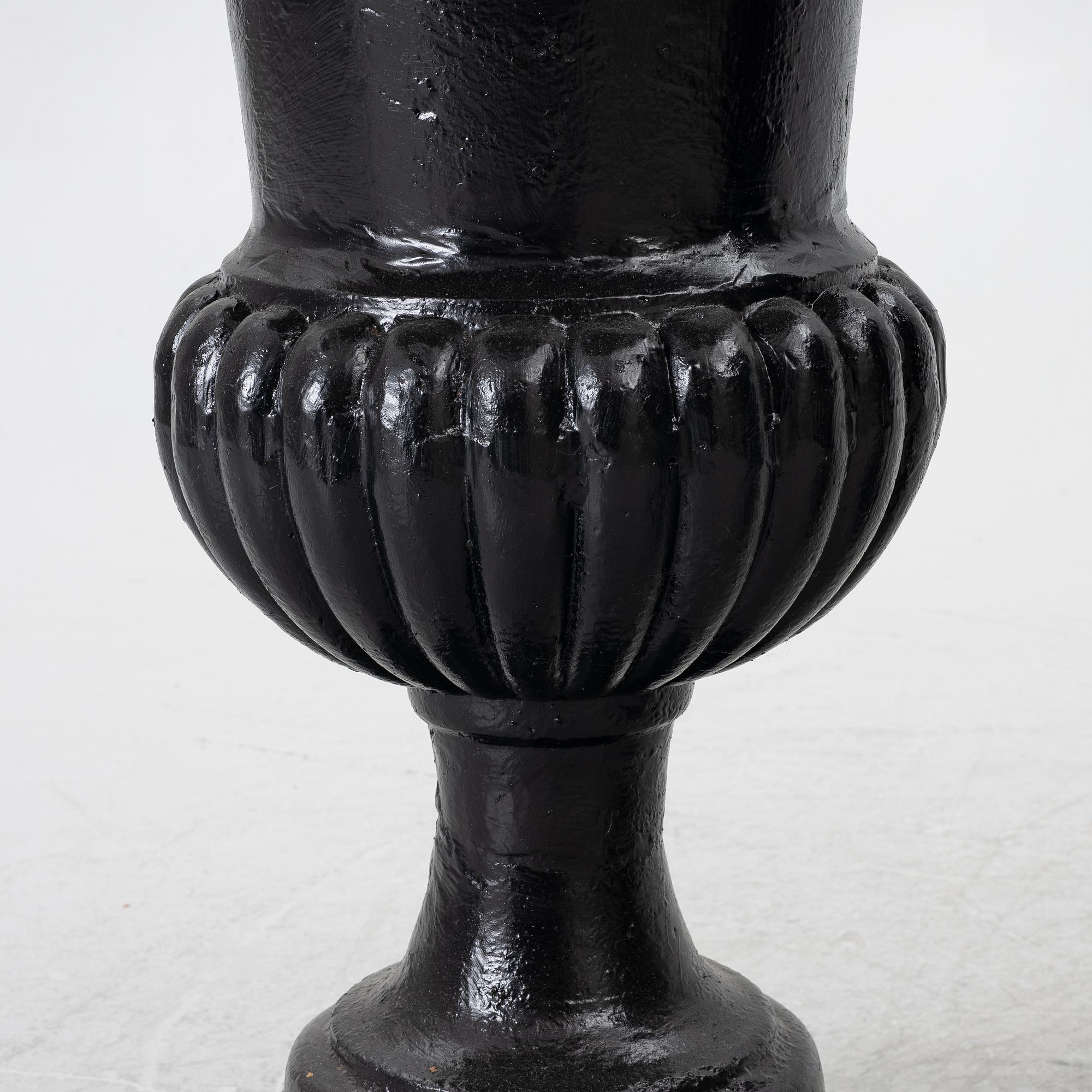 A pair of cast iron garden urns, 20th century.