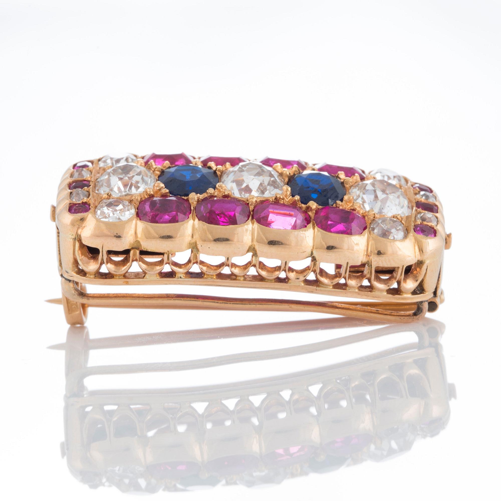 A brooch set with old-cut diamonds and faceted sapphires and rubies.