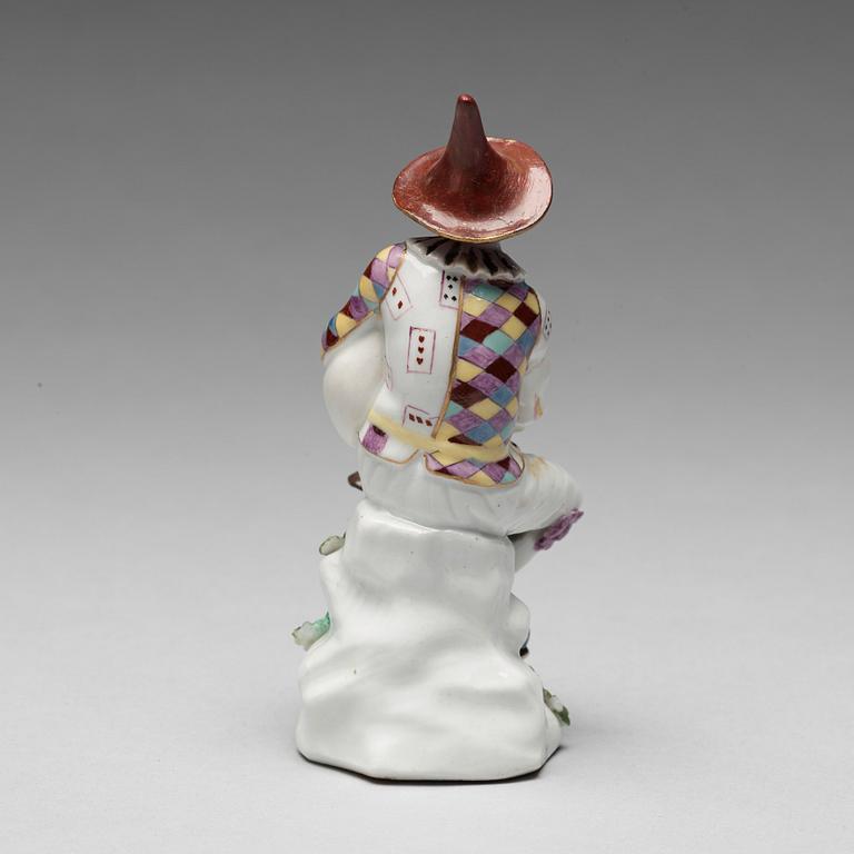 A porcelain figure of harlekin playing the bagpipe, circa 1900.