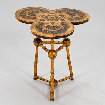 A wooden table from around 1900, cut decor.