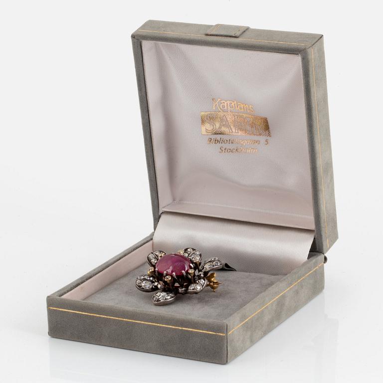 A brooch set with a cabochon-cut ruby ca 4.00 cts and old-cut diamonds.