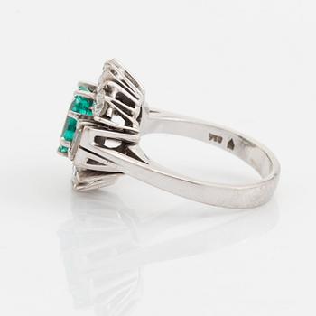 An 18K white gold ring set with a step-cut emerald.