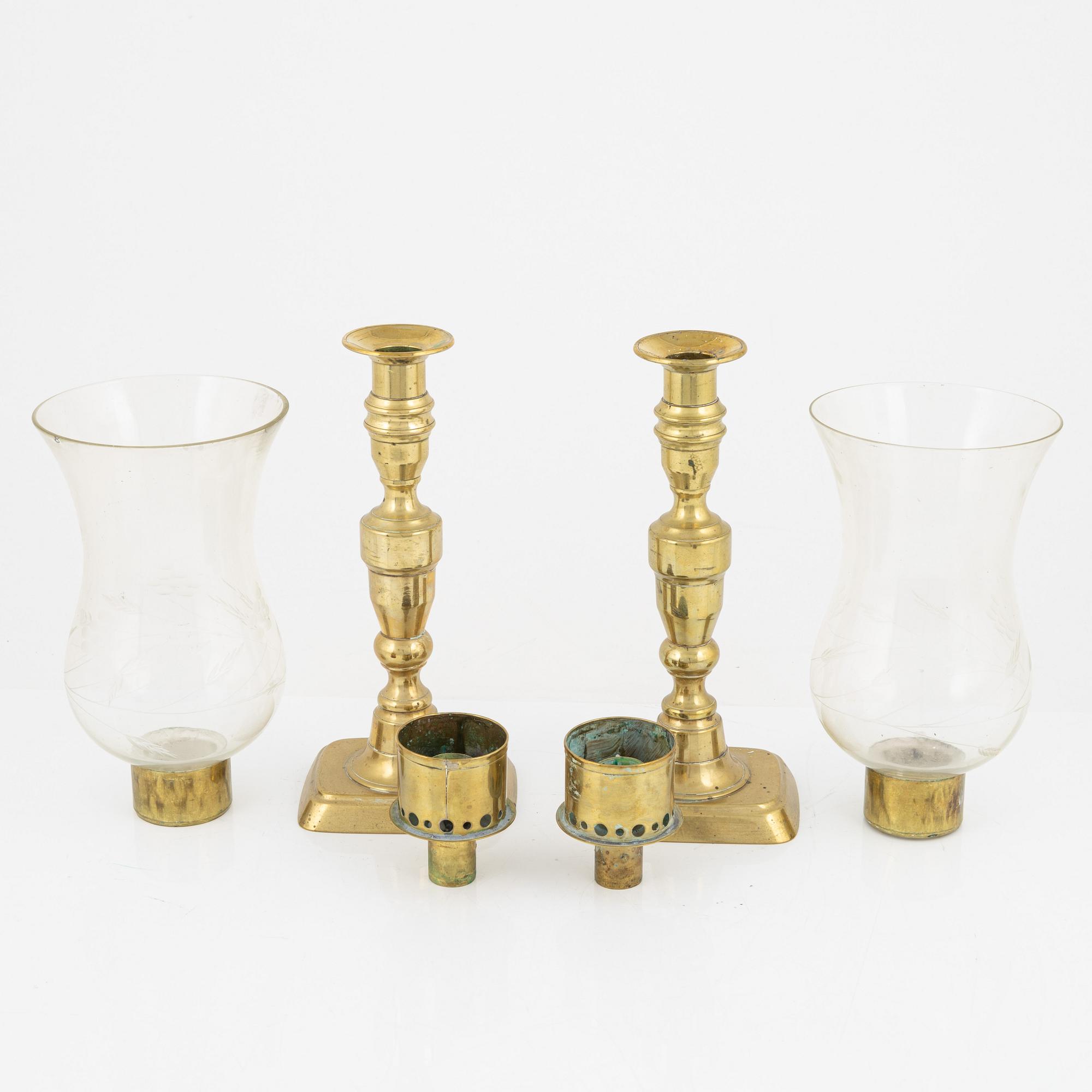A pair of brass candlesticks with storm glass, 19th century.