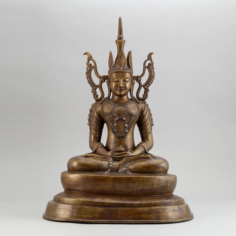 A seated buddha, yellow metal, possibly Nepal, 20th century.