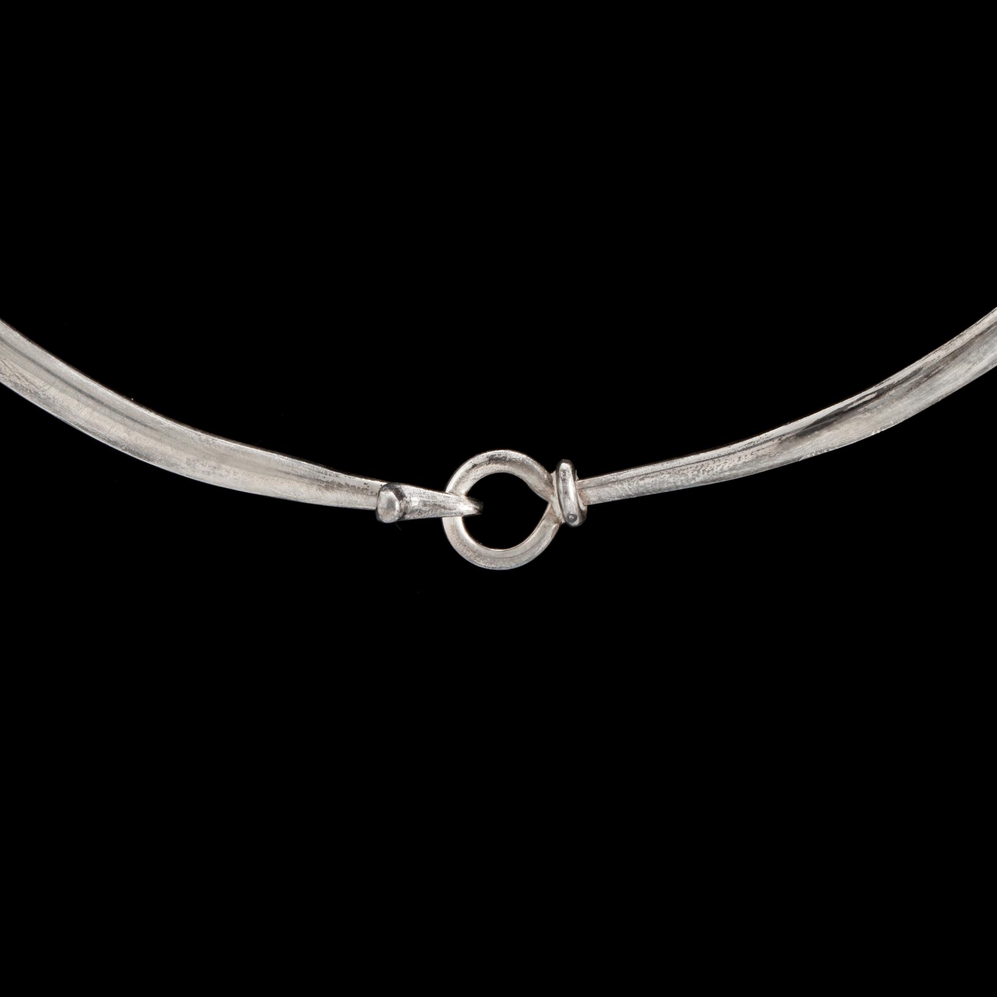 A silver, 'Dew Drop' neckring by VIVIANNA TORUN BÜLOW-HÜBE for Georg Jensen, Denmark, desgined 1955.