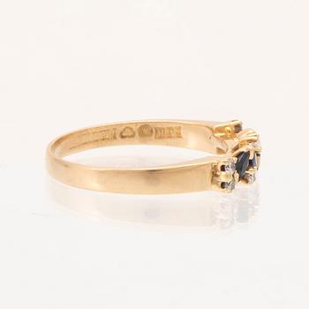 An 18K gold ring set with marquise cut, likely,  sapphires and round brilliant cut diamonds.