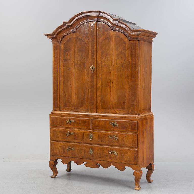 A walnut-veneered rococo cabinet in the manner of C. Linning, later part of the 18th Century.