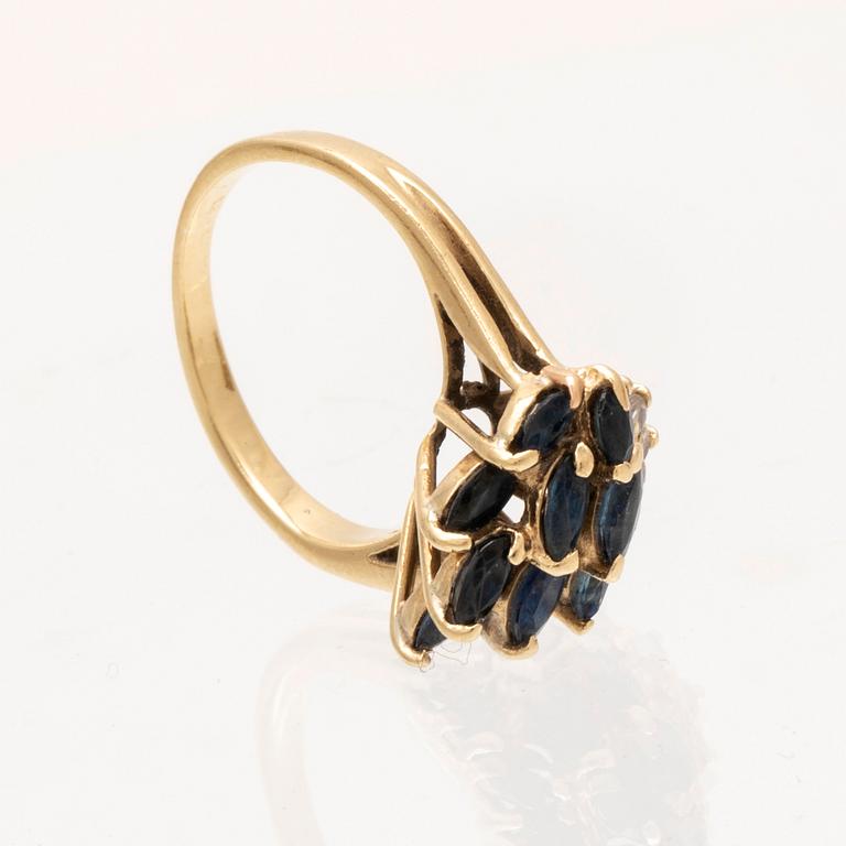 An 18K gold ring with marquise cut sapphires and round brilliant cut diamonds.