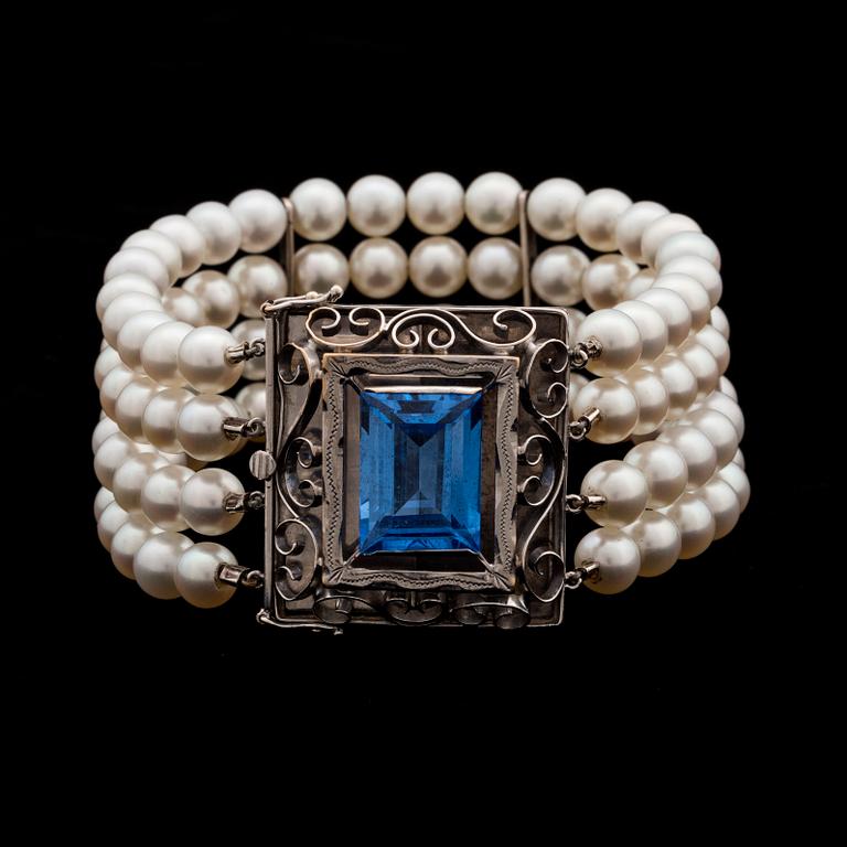 A bracelet with cultured akoya pearls and 18K gold clasp with blue faceted synthetic spinell.