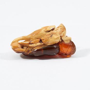 A carved amber figure/pendant of two squirrels sitting on some fruit, early 20th Century.