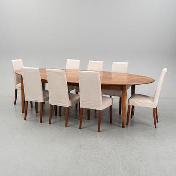 An stained oak dining table with eight chairs.