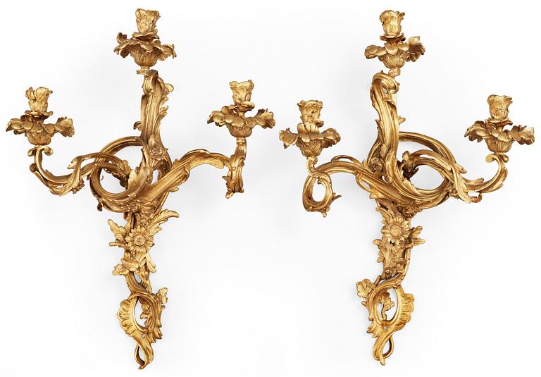 A pair of Louis XV-style late 19th century gilt bronze three-light wall-lights.