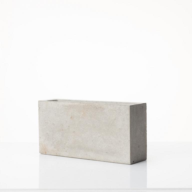 Stina Lindholm, a contemporary concrete planter 'Spira', a concrete flower pot and a wall clock.