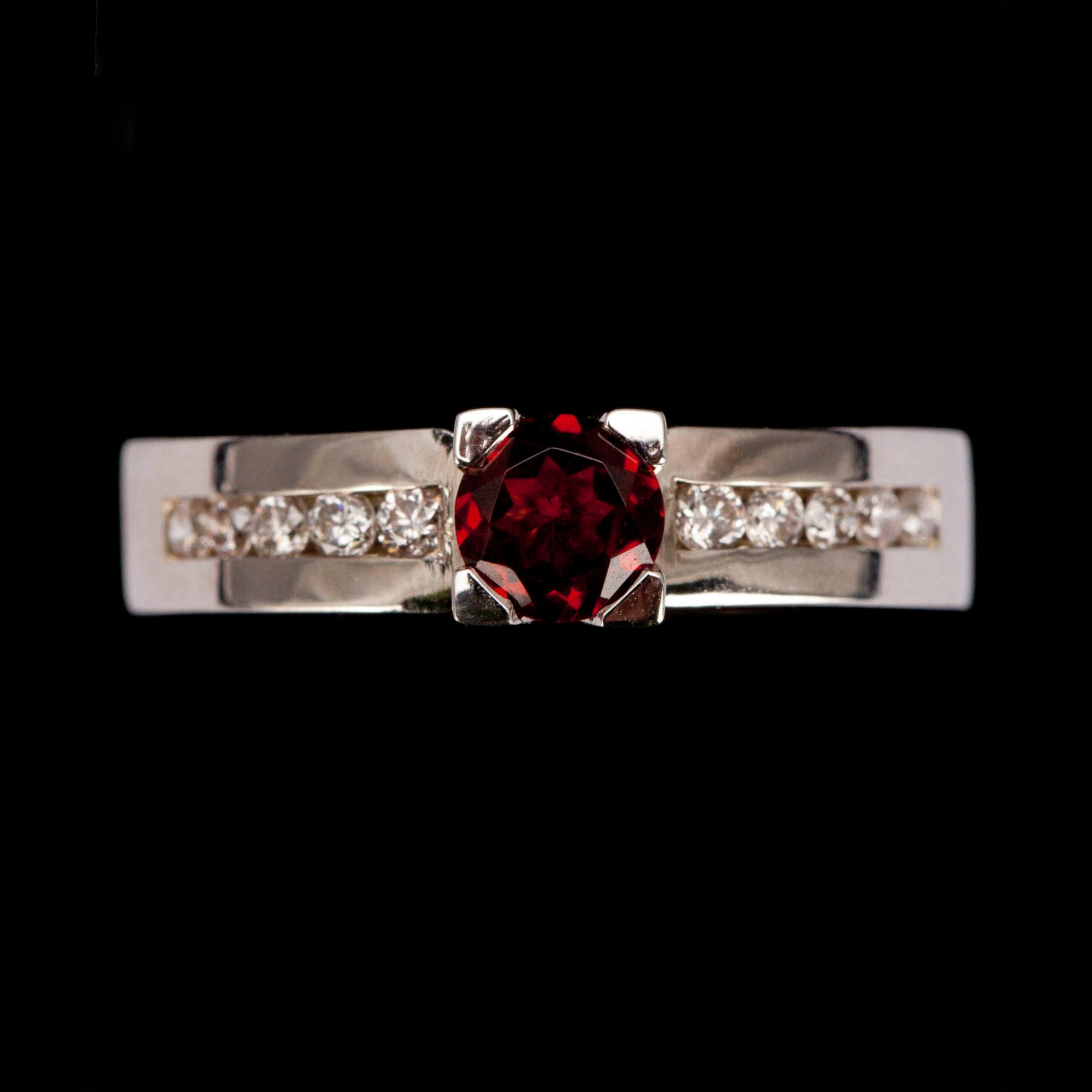 RING, vitguld 14K, fasettslipad granat 0,49 ct, briljantslipade diamanter diamanter tot. 0,21 ct. Vikt 4,7 g.
