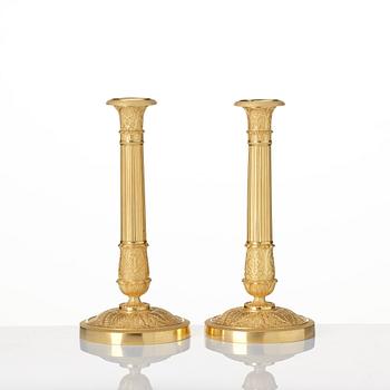 A pair of French Empire ormolu candlesticks, Paris, early 19th century.