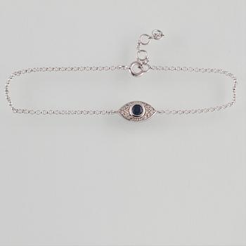 ARMBAND, 18K vitguld med briljantslipade diamanter ca 0.09 ct samt fasettslipad blå safir ca 0.18 ct Vikt 1,5 gram.