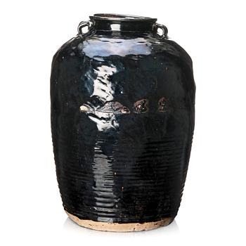 A large black glazed jar, presumably late Ming dynasty.
