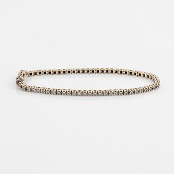 An 18K gold tennis bracelet set with round brilliant-cut diamonds.