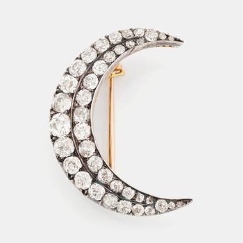 A Victorian crescent brooch in silver and gold set with old-cut dimonds.