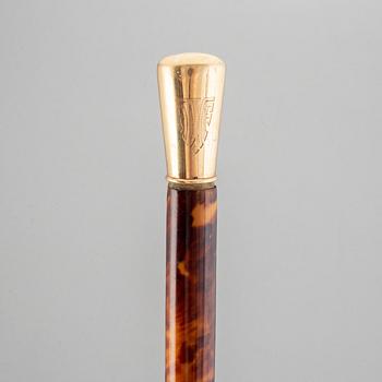 A tortoise imitation veneer, bone, and 14 ct gold walking stick.