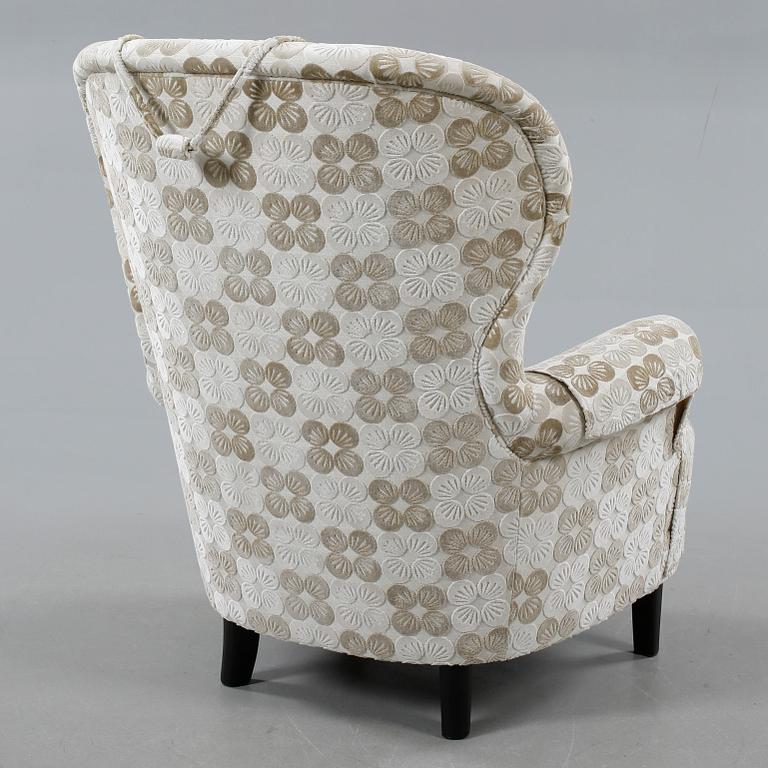 An armchair named "Rundrygg", designed by Carl Malmsten and made by OH Sjögren in 2011.