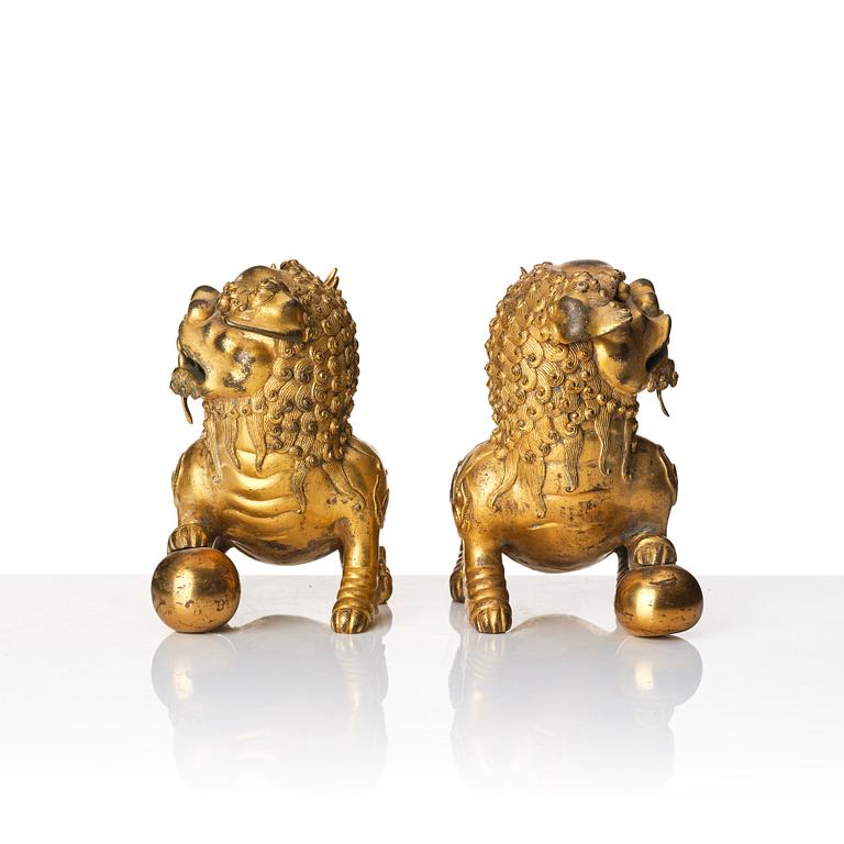 A pair of gilt bronze scultpures of buddhist lions, 18/19th Century.