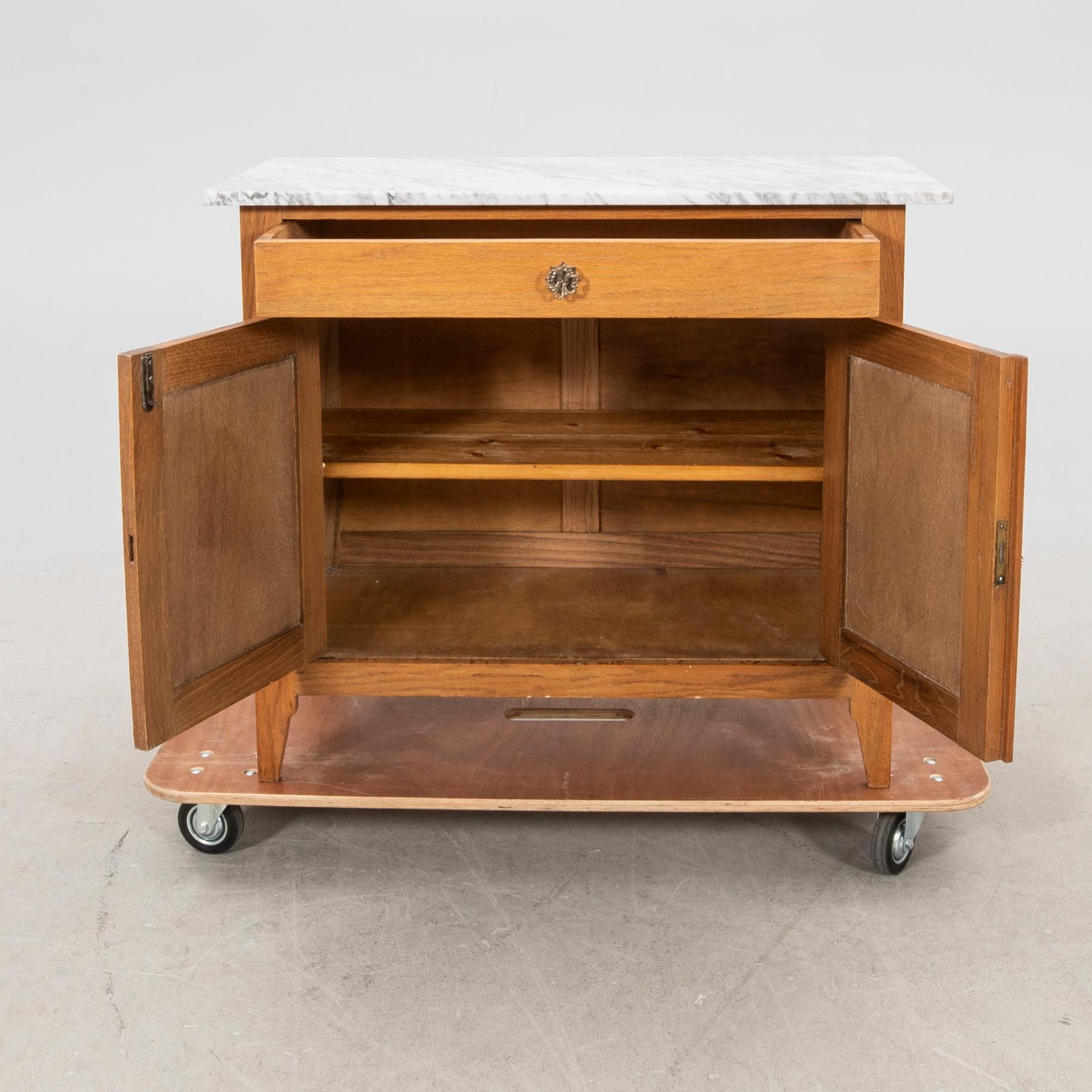 An early 1900s oak and marble cabinet.