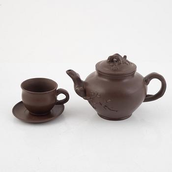 A Chinese yixing teapot with four cups and saucers, 2oth century.