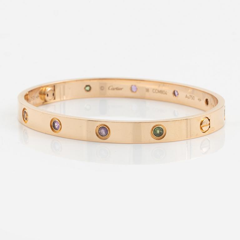 A Cartier "Love" bracelet in 18K rose gold set with colored stones.