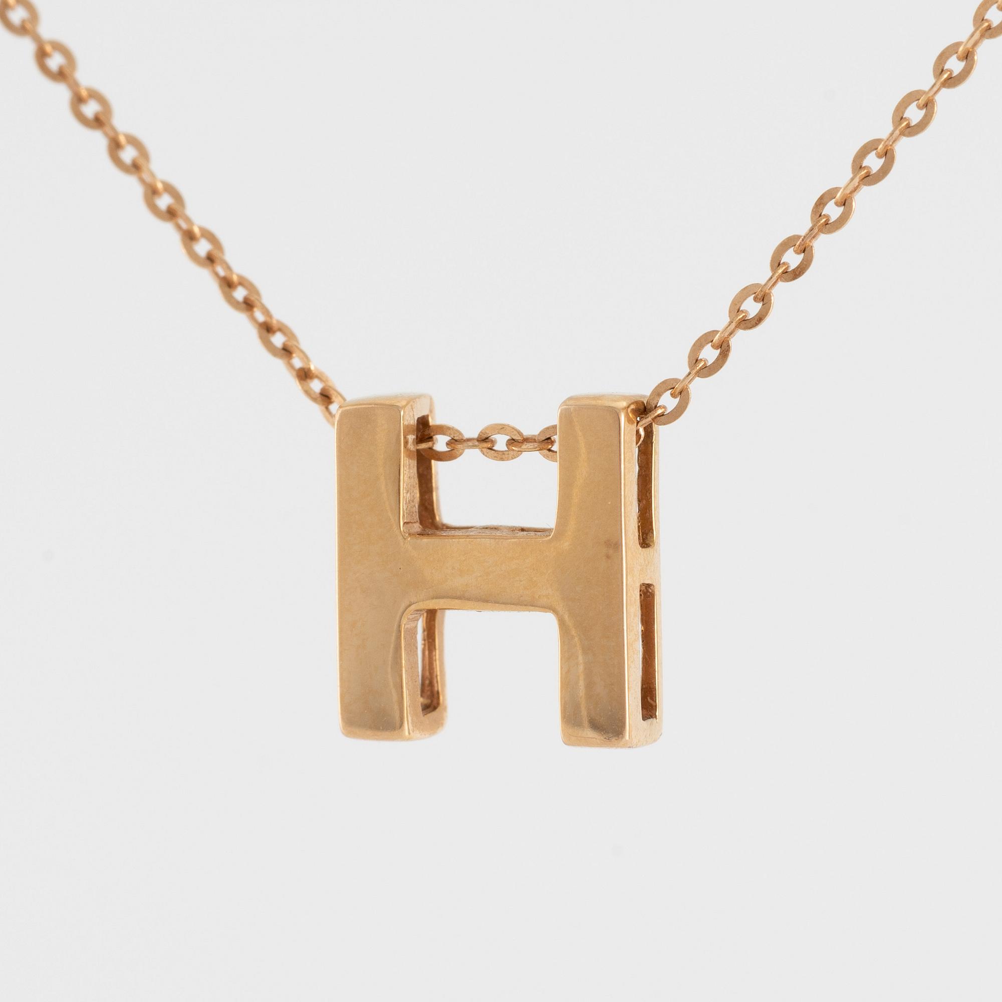 Collier, 18K guld med en berlock av bokstaven H.