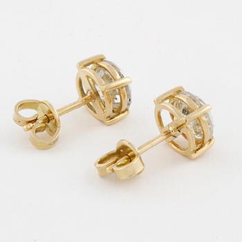 A pair of brilliant cut diamond earrings.