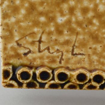 A stoneware wall plaque by Stig Lindberg, signed in the ceramics.