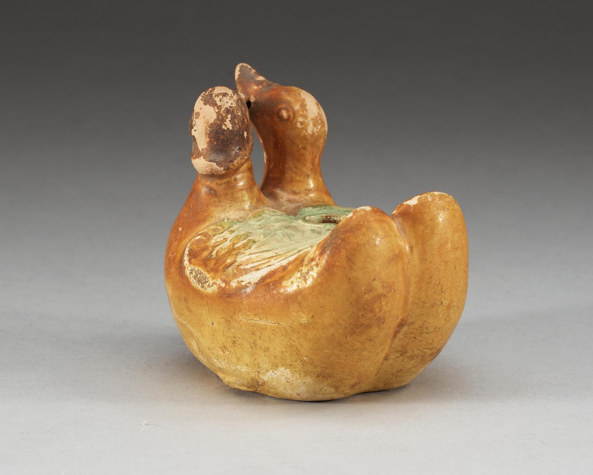 A yellow and green glazed figurine of two mandarin ducks. Ming dynasty ( 1368-1644).