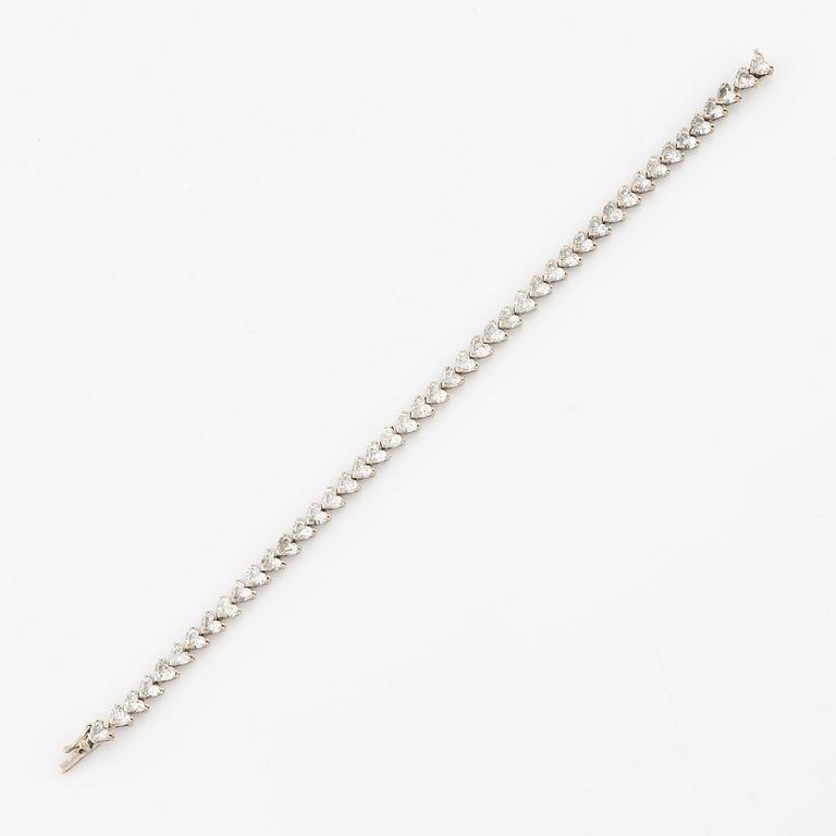 An 18K white gold bracelet set  with heart-shaped brilliant-cut diamonds.