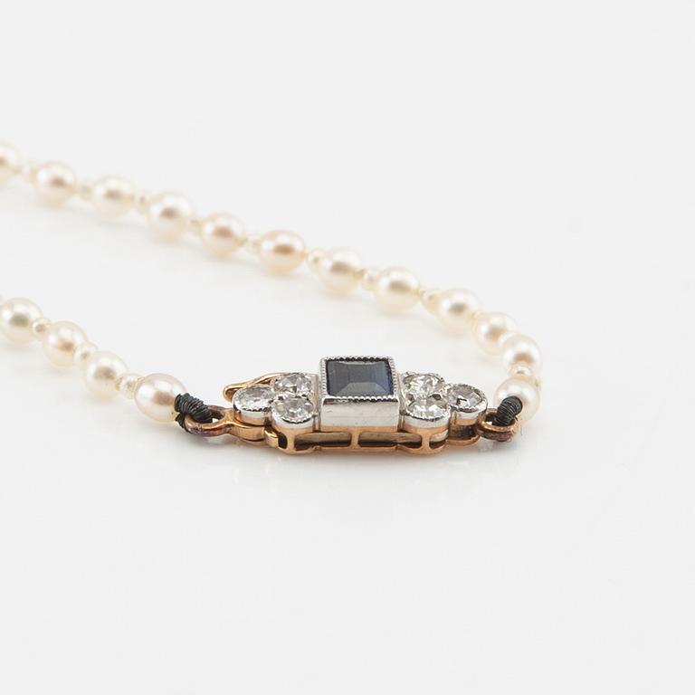 Necklace possibly cultured pearls with a clasp of 18K gold set with diamonds and a blue stone.